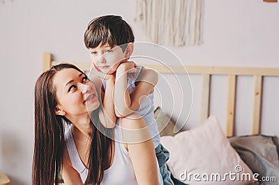 Happy loving mother hugs with child son in the morning in bed Stock Photo