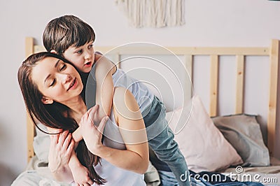 happy loving mother hugs with child son in the morning in bed. Stock Photo