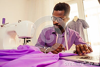 Happy male african designer constructor engineer writing down ideas in a notebook in studio Stock Photo
