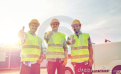 Happy male builders in high visible vests outdoors Stock Photo