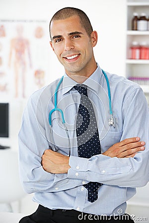 Happy Male doctor sat in consulting room Stock Photo