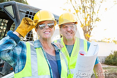 Happy Male and Female Workers With Blueprints Stock Photo