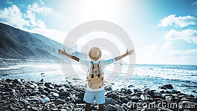 Happy man with arms up enjoying freedom on the beach - Hiker with backpack celebrating success outdoor Stock Photo