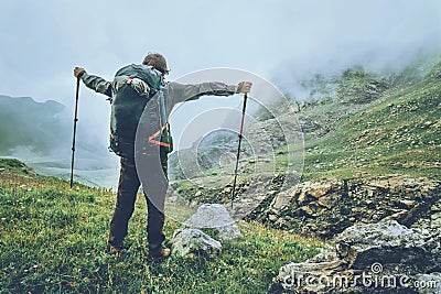 Happy Man backpacker hiking in foggy mountains Stock Photo