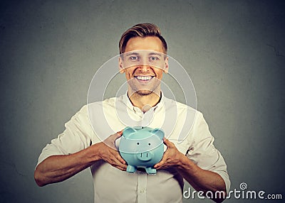 Happy man with blue piggy bank Stock Photo