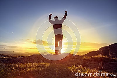 Happy man celebrating winning success against sunset Stock Photo