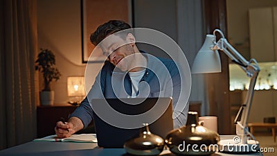 Happy man enjoy call noticing notebook at evening apartment closeup. Guy talking Stock Photo
