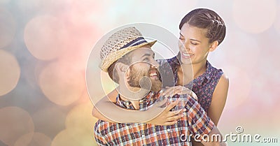 Happy man giving piggyback ride to woman over bokeh Stock Photo