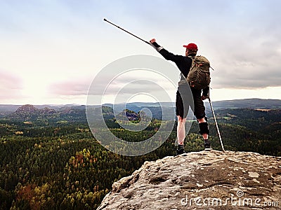 Happy man hiker holding medicine crutch above head, injured knee fixed in knee brace feature Stock Photo