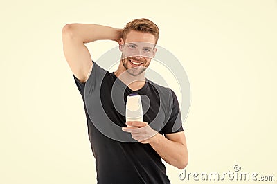 Happy man hold shampoo bottle isolated on white. Bearded man smile with gel tube. Hairdresser salon and barber. Hygiene Stock Photo