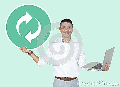 Happy man holding a laptop and a refresh icon Stock Photo