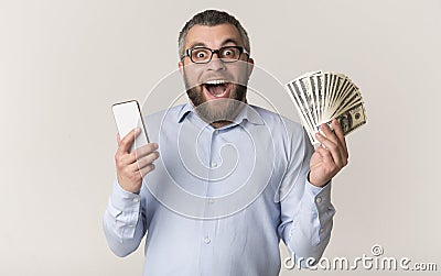 Happy man holding smartphone and showing bunch of money Stock Photo