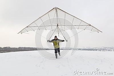 Happy man holds vintage hang glider wing Stock Photo