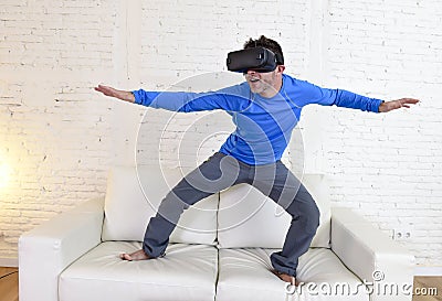 Happy man at home living room sofa couch excited using 3d goggles virtual reality surfing Stock Photo