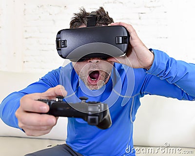 Happy man at home living room sofa couch excited using 3d goggles watching 360 virtual reality Stock Photo
