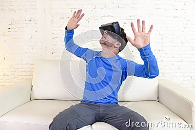 Happy man at home living room sofa couch excited using 3d goggles watching 360 virtual reality Stock Photo