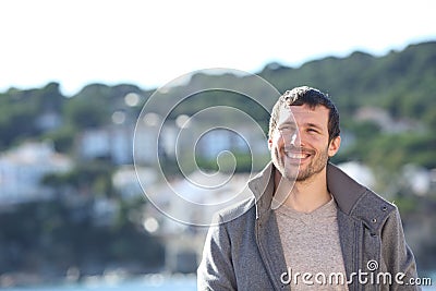 Happy man looking sideways in a town in winter Stock Photo