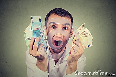 Happy man with money euro banknotes ecstatic celebrates success Stock Photo