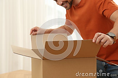 Happy man opening parcel, closeup. Internet shopping Stock Photo