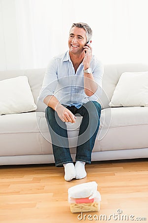 Happy man phoning on the couch Stock Photo