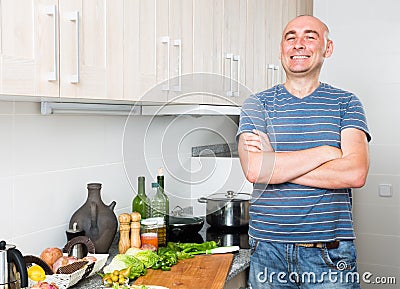 Happy man in the prime of life in kitchen prepared two salads Stock Photo