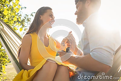 Happy man putting engagement ring on the finger of girlfriend on Stock Photo