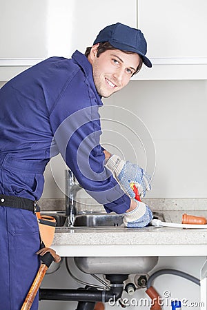 Happy man repairing de sink Stock Photo