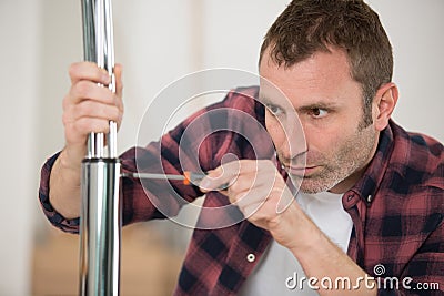 happy man screwing screws into furniture fittings Stock Photo