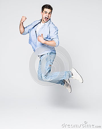 Happy man in shirt and jeans which jumping in studio over white background Stock Photo