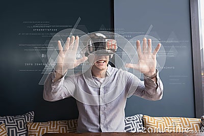 Happy man in VR headset touching interfaces with flares Stock Photo