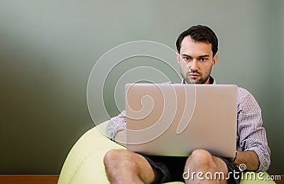 Happy man working from home using laptop Stock Photo