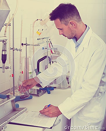 Happy man working on quality of products in lab Stock Photo