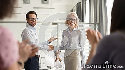 Happy manager boss praising old employee get team appreciation Stock Photo
