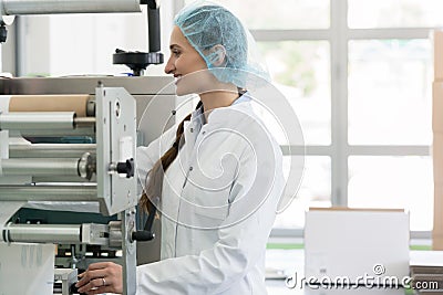 Happy manufacturing operator working with modern equipment in fa Stock Photo