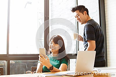 Happy marriage couple reading incoming sms message on smartphone connected to free wifi while drinking coffee in morning. Selectiv Stock Photo