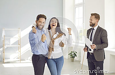 Happy married couple is joyfully and contentedly clenching their fists during meeting with realtor. Stock Photo