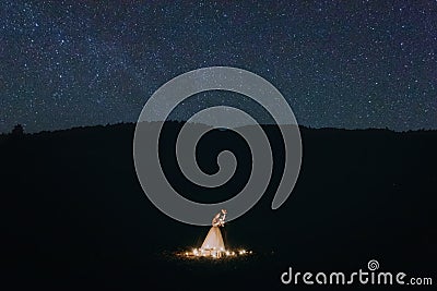 Happy married couple romantically hugging under starry sky Stock Photo