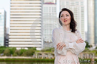 Happy mature beautiful businesswoman at the park in the city Stock Photo