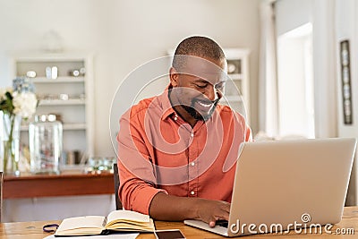 Happy mature black man using laptop Stock Photo