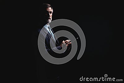 Happy mature businessman working with modern tablet isolated on black background. Stock Photo