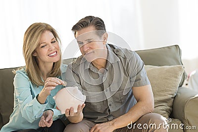 Happy Mature Couple With Piggybank At Home Stock Photo