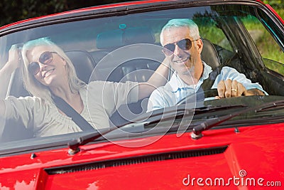 Happy mature couple in red cabriolet Stock Photo