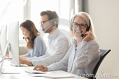 Happy mature female call center agent looking at camera smiling Stock Photo