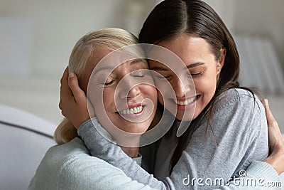 Loving elderly mother and adult daughter hug at home Stock Photo