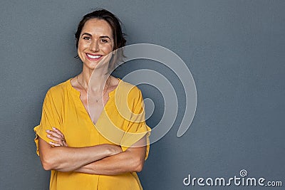 Happy mature woman smiling on grey wall Stock Photo
