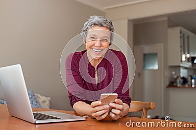 Happy mature woman using smartphone Stock Photo