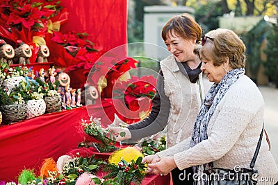 Happy mature women selecting floral compositions Stock Photo