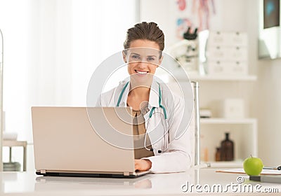 Happy medical doctor woman working on laptop Stock Photo