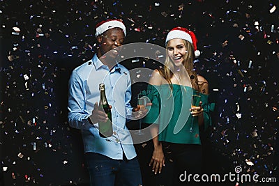 Joyful couple congratulating on christmas with champagne at black background Stock Photo