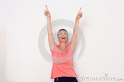 Happy middle age woman laughing with arms raised and pointing fingers up Stock Photo